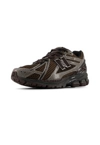 Αθλητικό παπούτσι σκούρου καφέ με υφή σε σχέδιο, πλέγμα σε πάνελ, και εμφανές λογότυπο. Διαθέτει εύκαμπτη σόλα και δέσιμο με κορδόνια.