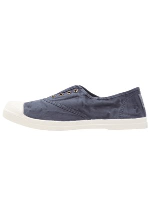Zapatilla de lona marina sin cordones con puntera y suela de goma blanca, que presenta pequeños ojetes metálicos y acentos de costura texturizada.