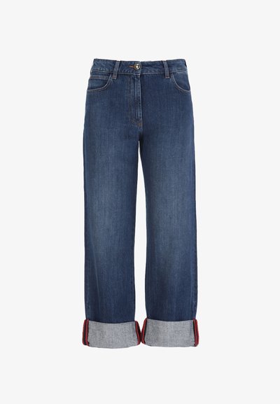 Tamnoplave široke hlače od trapera sa savijenim rubovima koji otkrivaju crveno-crne prugaste unutarnje obloge, zatvaranje na dugme i patentni zatvarač te prednjem džepu.