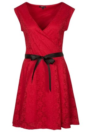 Robe en dentelle rouge avec manches courtes et encolure en V, ornée d'un ruban de satin noir noué en un nœud à la taille.