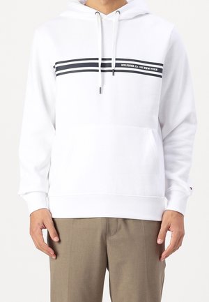 Sudadera blanca con bolsillo canguro frontal, cordones grises y detalles de rayas azul marino. Presenta texto del logo en el pecho. Material de algodón suave.