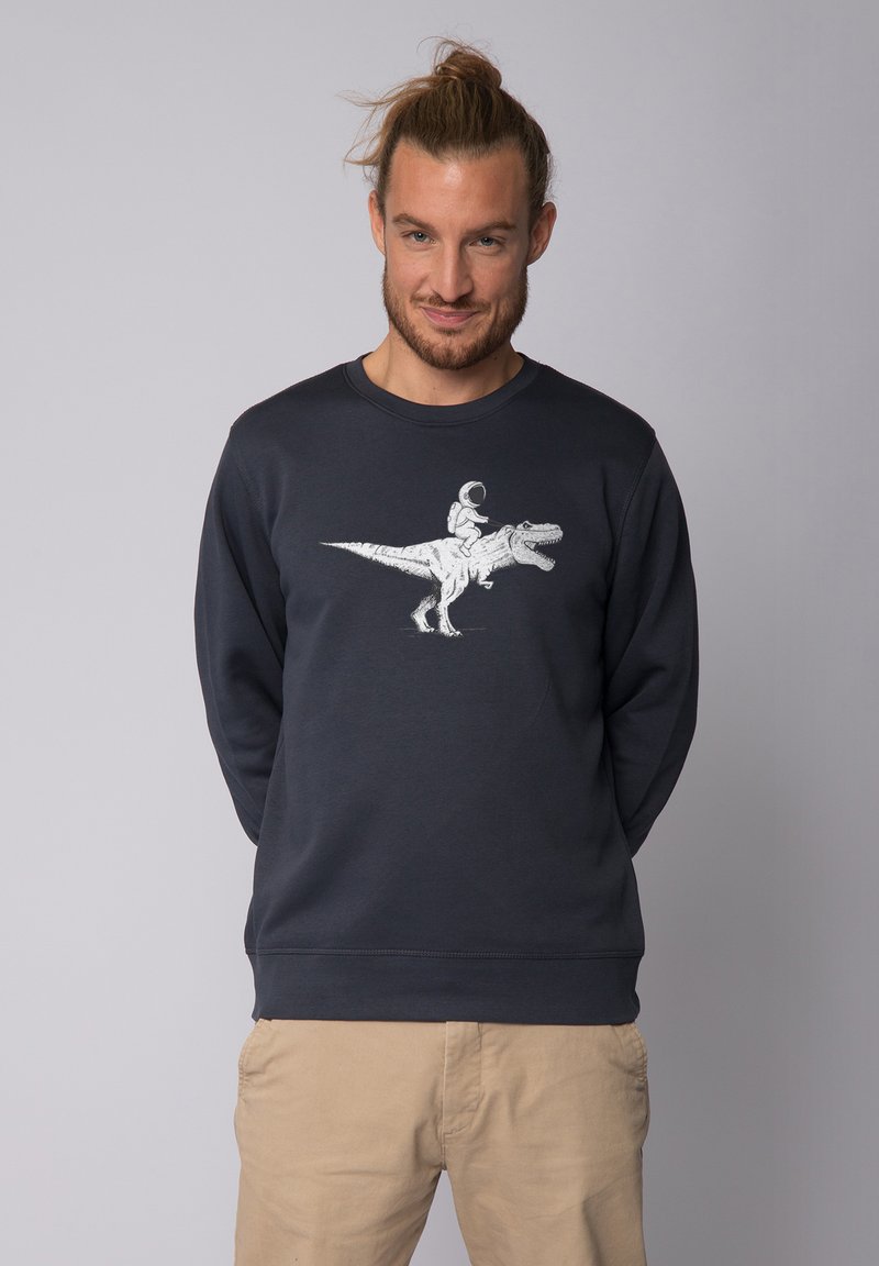 Sweatshirt marine à manches longues avec un graphique blanc représentant un dinosaure et un astronaute. Matière en mélange de coton avec un design à col rond.