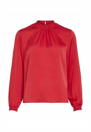 Blusa roja de manga larga en tela suave con un cuello alto, puños elásticos y detalles fruncidos en el escote.