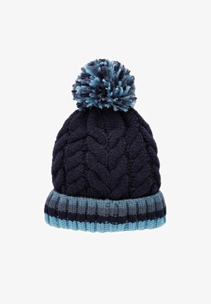 Námornícky pletený beanie s bambulí, který má texturu kabelového pletení a vícebarevný modrý pruhovaný žebrovaný pásek na spodní části.
