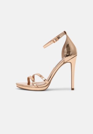 Sandale à talon haut en métal rose doré brillant avec bride à la cheville et deux fines lanières avant, semelle compensée et talon aiguille.
