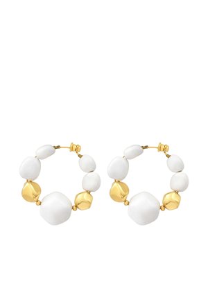 Paire de boucles d'oreilles créoles en or avec des accents de perles blanches et dorées irrégulières sur un fond blanc.