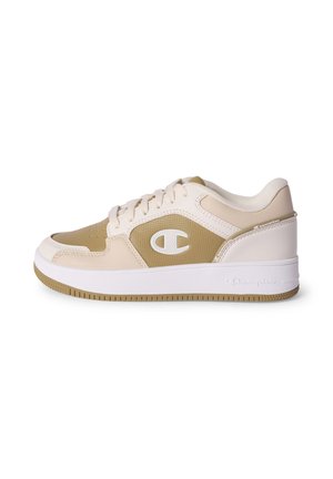 Baskets basses beige et blanches avec lacets blancs, panneau latéral texturé et semelle en caoutchouc blanche avec logo Champion sur le côté et le talon.