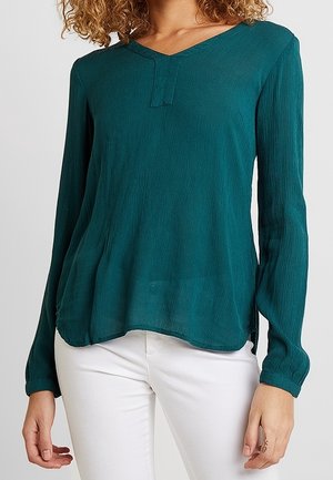 Turquoise, top met lange mouwen gemaakt van lichtgewicht stof met een V-hals en subtiele plooien bij de schouders, met een afgeronde zoom.