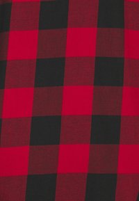 Motif à carreaux de buffle rouge et noir avec de grands carrés espacés uniformément alternant les couleurs.