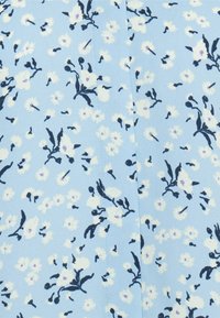 Tecido azul claro com um padrão floral, apresentando flores brancas e folhas azul-escuras, realçado por pequenos detalhes roxos e costura visível.