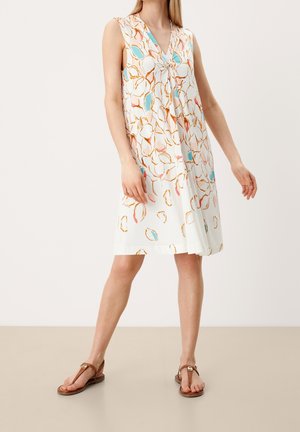 Robe sans manches en V avec un tissu blanc ornée d'un imprimé de feuilles colorées en orange, rose et bleu ; coupe ample avec un design fluide.
