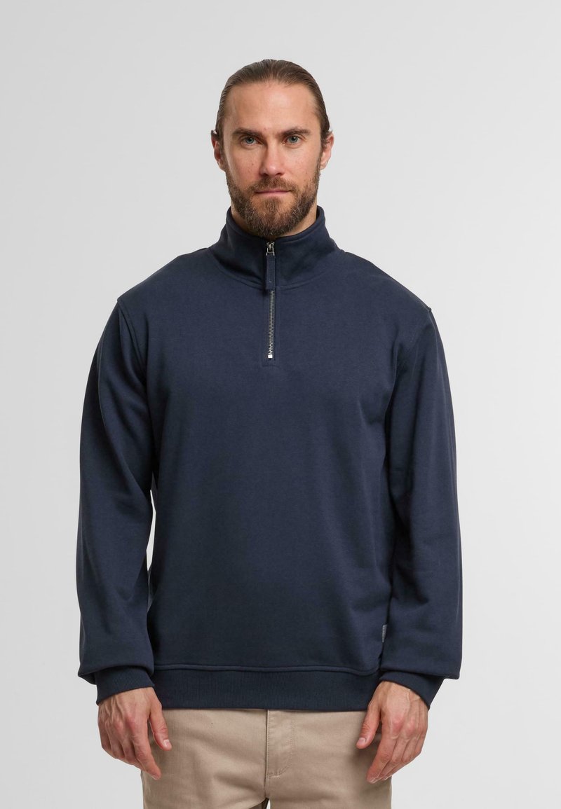 Navy blue zip-neck sweatshirt with long sleeves. Soft, stretchy fabric, featuring a minimalistic design and ribbed cuffs and hem.