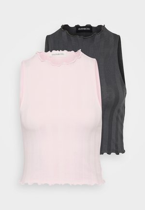 Dve tielka bez rukávov, jedno ružové a jedno tmavošedé, sú s rebrovým vzorom a volánovými výstrihmi; obidve sú navrhnuté na priliehavý strih.