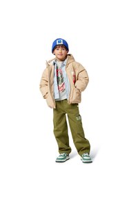 Beżowa kurtka puchowa, jasnoniebieska koszula w paski, szara koszulka z grafiką, zielone spodnie cargo z łatą, niebieska czapka dziana, zielono-białe sneakersy.