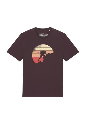 Donkerbruine T-shirt met een ontwerp van een persoon die een bergsilhouet beklimt tegen een gestreepte cirkelvormige zonsondergang achtergrond.