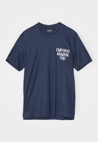 Námořnická modrá bavlněná trička s krátkým rukávem. Na levé hrudi se nachází bílé tištěné logo "EMPORIO ARMANI 1981". Standardní střih, kulatý výstřih.