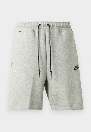 Shorts Nike gris clair avec cordons noirs, taille élastique, poches latérales et petit logo Nike noir sur la jambe gauche.
