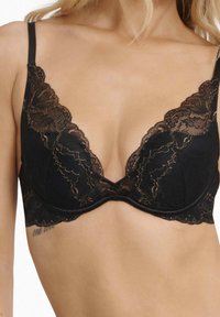 Czarny koronkowy biustonosz z głębokim dekoltem, z misternym koronkowym wykończeniem i gładką, jednolitą warstwą spodnią. Regulowane ramiączka i złote akcenty.