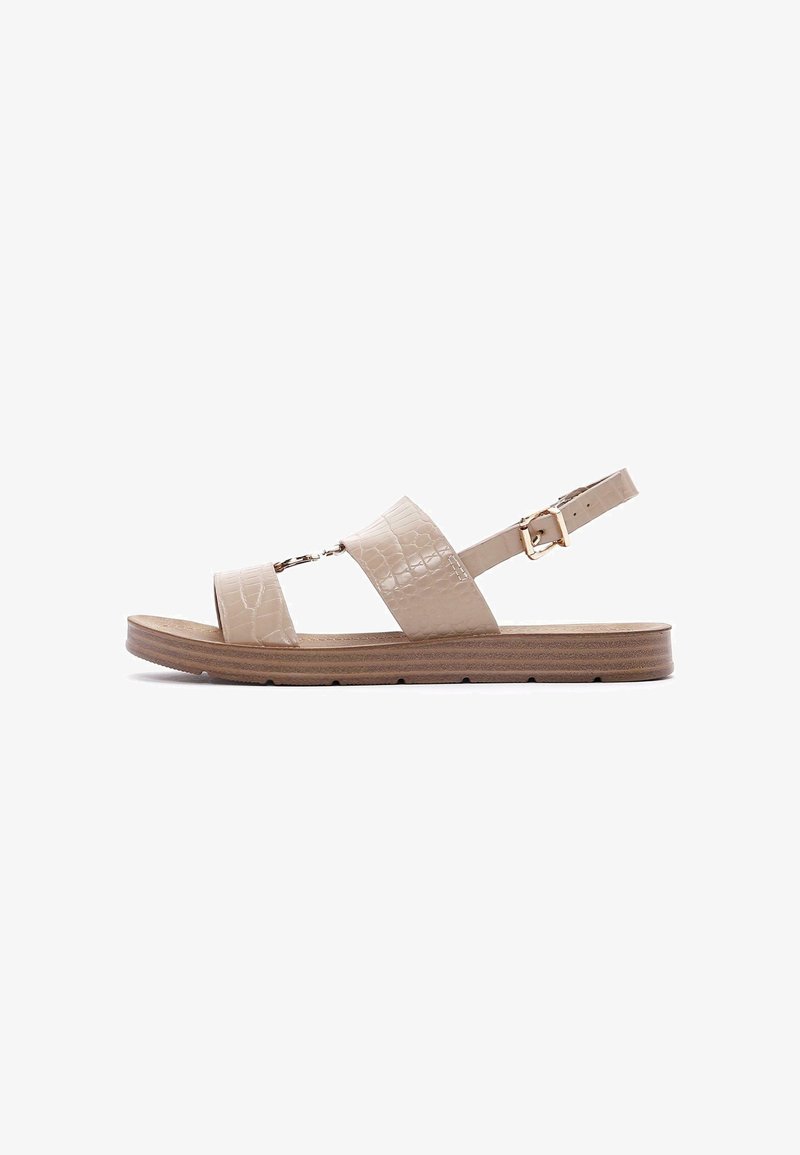 Beige sandalen met krokodillenhuid-embossed banden, verstelbare enkelgesp en een gestructureerde bruine zool, met twee brede voorbanden.