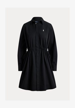 Svart skjortekjole med lange ermer, krage, knapper foran, knytting i innsvinget midje og liten hvit brodert logo på brystet.