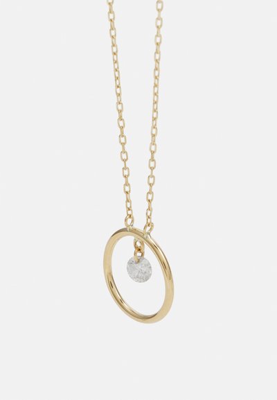 Arany nyaklánc, kör alakú medállal, amelyben egy tiszta, kerek kő lóg a körben, finom láncon.