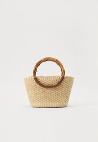 Borsa intrecciata in paglia con forma rastremata, colore beige naturale e manico circolare in bambù avvolto in pelle marrone.