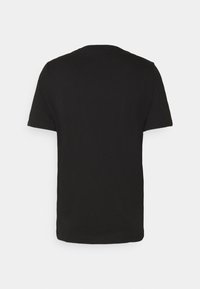 Camiseta negra de manga corta vista desde la parte de atrás sobre un fondo blanco.