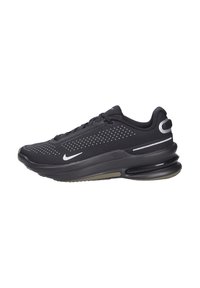 Zapatillas Nike negras con parte superior de malla, detalles perforados, suela gruesa y acolchada, y acentos plateados cerca del talón y el logo.