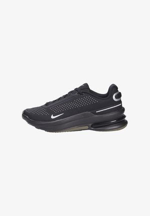 Zapatillas Nike negras con parte superior de malla, detalles perforados, suela gruesa y acolchada, y acentos plateados cerca del talón y el logo.