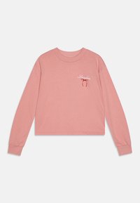Sudadera corta de manga larga color rosa con puños acanalados, que presenta el texto blanco "London" y un diseño de lazo rojo en el área del pecho izquierdo. Tela suave.