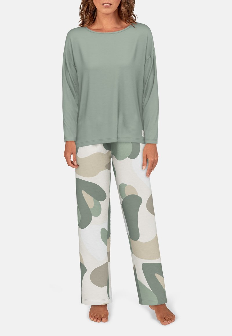 Šviesiai žalia ilgas rankoves turinti palaidinė su laisvu kirpimu, derinama su smėlio ir žaliais raštuotais pižamų kelnėmis, pagamintomis iš minkštos medžiagos. Nėra matomų logotipų.