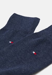 Marineblå bomuldsstrømper med ribbet tekstur og et lille logo i rød, hvid og blå på anklen. Ankel-længde design.
