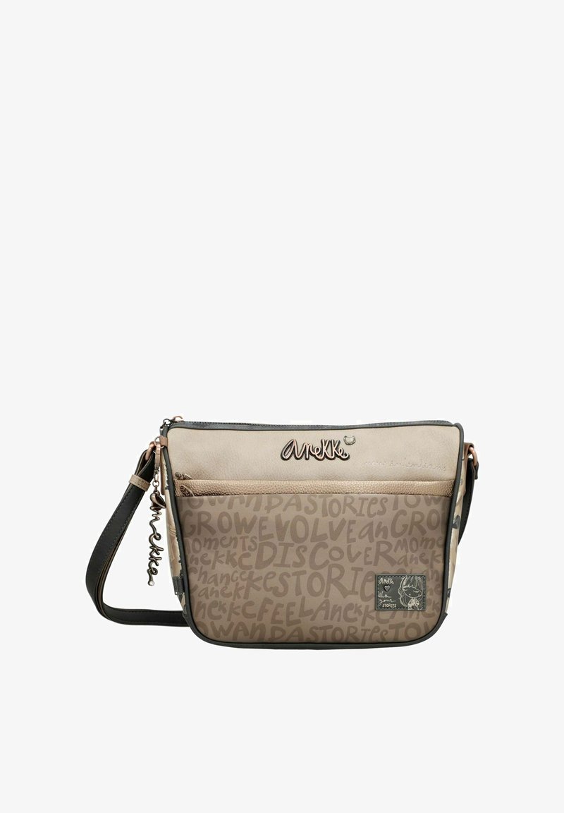 Bolso bandolera beige con una sección superior lisa y una sección inferior con estampado. Cuenta con detalles en oro rosado, un charm desmontable y una correa ajustable.
