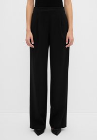 Zwarte wijde broek van zachte stof, met voren geplooide details, een hoge taille en een op maat gemaakte snit.