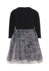 Czarna sukienka z długim rękawem, z teksturowanym gorsetem i przezroczystą szarą spódnicą z geometrycznym wzorem. Zamek błyskawiczny z tyłu przy dekolcie.