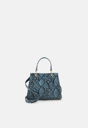 Sac à main imprimé peau de serpent bleu et noir avec doubles poignées et une longue bandoulière sur un fond uni clair.