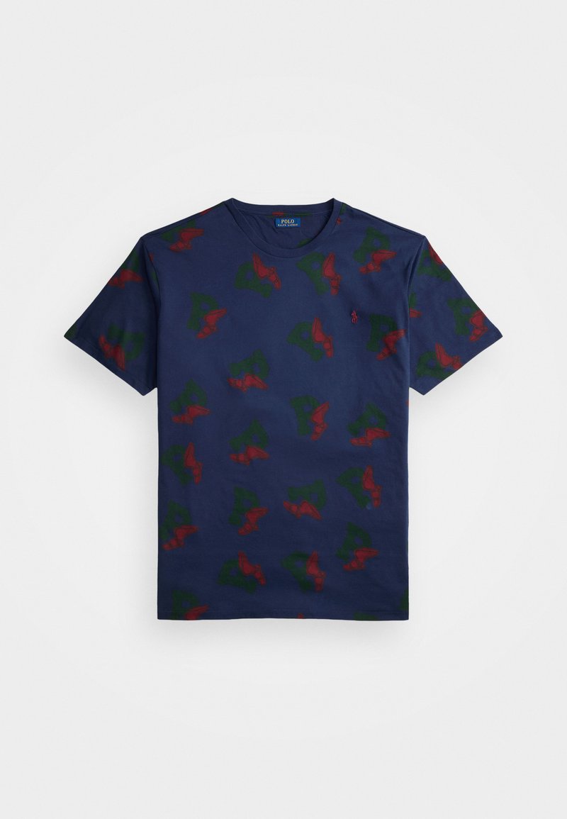 Marineblå bomulds t-shirt med et gentaget mønster af røde og grønne vinge-designs. Har rund hals og korte ærmer.