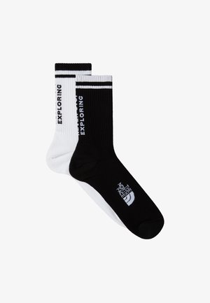 Calcetines de crew de rayas en blanco y negro con el texto "EXPLORANDO" y el logo de "The North Face" en colores contrastantes. Material mezclado de algodón.