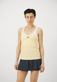 Yellow athletic tank top with white straps and black logo, paired with a dark blue skort featuring a pleated design and performance fabric.