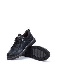 Zapatos de cuero negro con un diseño de cordones, presentado con una cremallera lateral, plantilla acolchada y suela de goma texturizada con un patrón de tracción transparente.