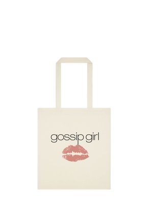 Sac cabas beige avec longues anses portant les mots « gossip girl » et une trace de baiser au rouge à lèvres rose sous le texte.