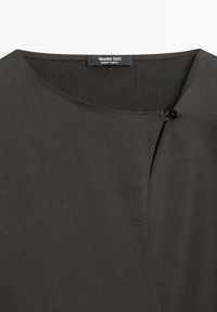 Indumento verde scuro con scollo rotondo, dotato di chiusura a bottoni e trama liscia. L'etichetta riporta la scritta "Massimo Dutti."