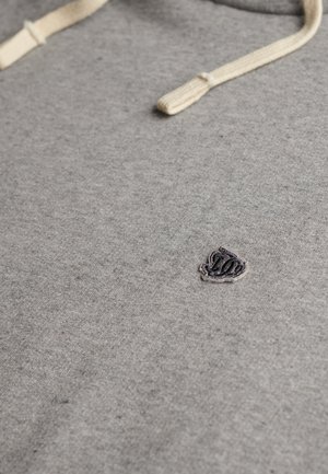 Szara bluza z miękką teksturą, z kremowymi sznurkami i małym, ciemnoszarym haftowanym logo na piersi.