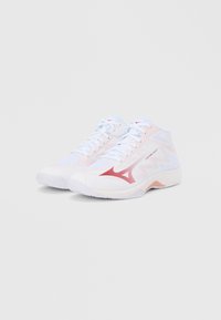 Λευκά αθλητικά παπούτσια ψηλού τύπου με ροζ λεπτομέρειες. Διαθέτουν υφή στο επάνω μέρος και λεπτό, κόκκινο αντίθετο λογότυπο στο πλάι. Ελαφρύς σχεδιασμός.