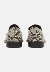 Pár nazouvacích bot s černými podrážkami a hnědo-bílým hadím vzorem, pohled zezadu na bílém pozadí.