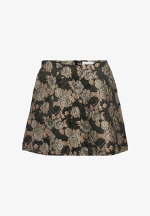 Jupe évasée en tissu noir présentant un motif floral texturé en beige et or. La taille est droite avec des détails de plis.