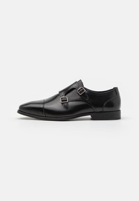 Schwarze Leder-Oxfords mit spitzer Zehenpartie, ausgestattet mit doppelten Schnallen und einer glatten Oberfläche. Niedriger Absatz und elegantes, schlichtes Design.