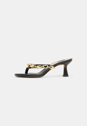 Černá otevřená sandála na podpatku s páskem zdobeným zlatými korálky a čtvercovou špičkou na bílém pozadí.