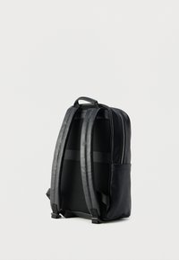 Μαύρο δερμάτινο σακίδιο με δομημένο σχεδιασμό, επενδεδυμένους ιμάντες ώμου, πίσω μέρος από δίχτυ και πλαϊνή τσέπη. Διαθέτει κλείσιμο με φερμουάρ.