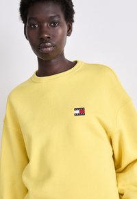 Tommy Jeans BADGE CREW - Felpa - yellow dahlia